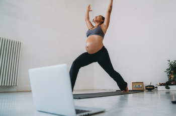 Pregnant woman doing yoga online